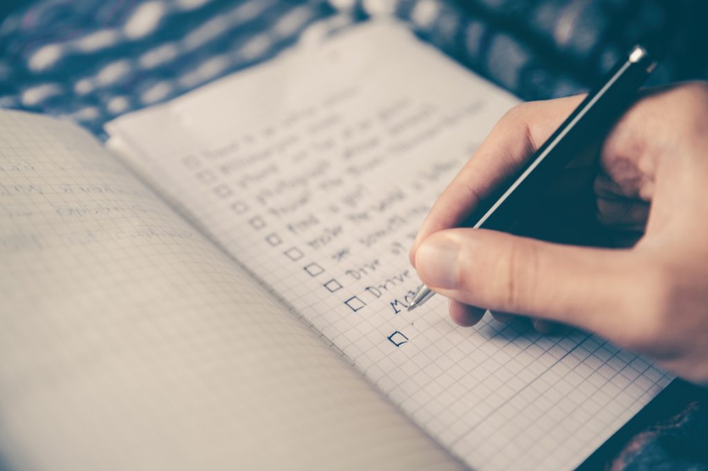 hand with pen writing in notebook