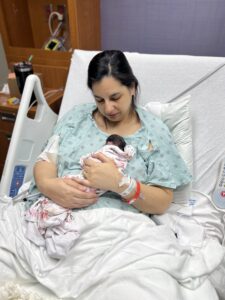 mother holding baby on chest in hospital bed