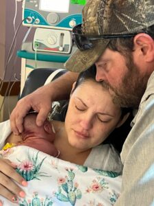 Woman and Man embracing with baby after birth