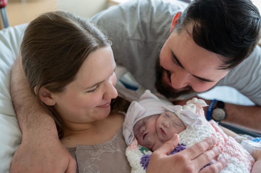 Proud Mama & Papa Bear hold not one, but two sweet girls, Laelle & Levia.