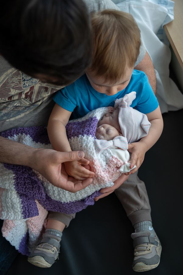 Big brother holds not one but two baby sisters!